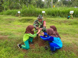 Babinsa Koramil Ngetos Kodim 0810/Nganjuk melakukan penanaman pohon penghijauan di lingkungan SDN 5 Klodan