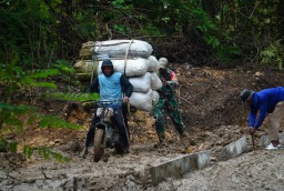 Sigap Bantu Warga, Babinsa di Lokasi TMMD Bantu Dorong Motor di Medan Berlumpur