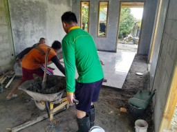 Anggota Satgas TMMD 124 Kodim Nganjuk Bersama Warga Pasang Keramik