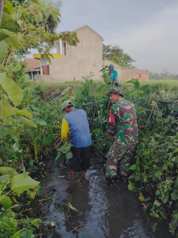 Babinsa Prambon Bersama Warga Gotong Royong Bersihkan Aliran Sungai di Desa Kurungrejo