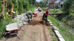 Babinsa Koramil 0810/09 Ngronggot Ajak Warga Desa Betet Gotong Royong Pasang Paving Jalan