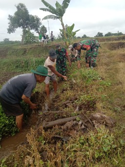 Babinsa dan Warga Desa Kuncir Gelar Karya Bakti Bersihkan Saluran Irigasi