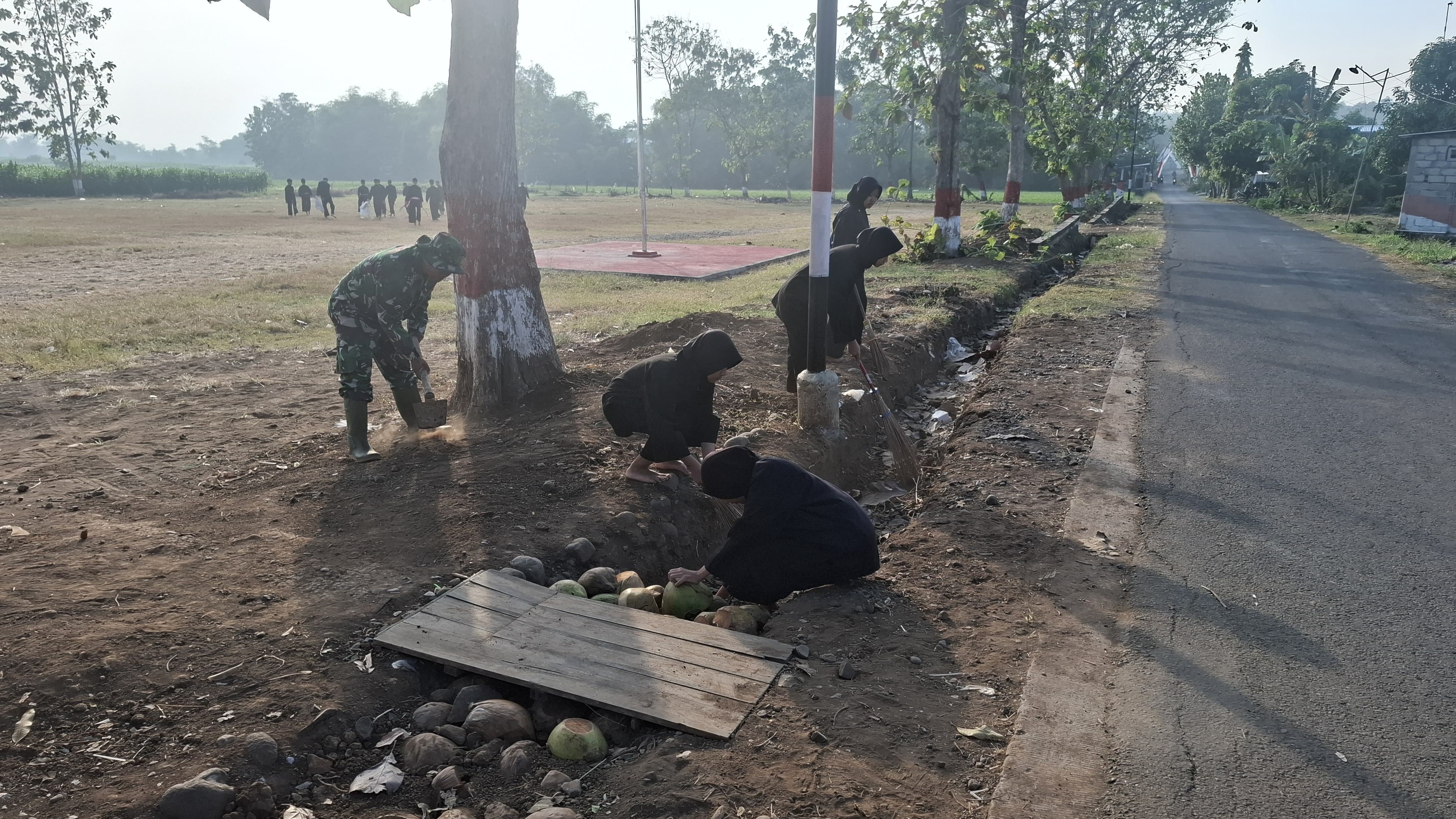 Babinsa Desa Kuncir Bersama Warga Kerja Bakti Bersihkan Lapangan untuk Upacara HUT RI ke-80