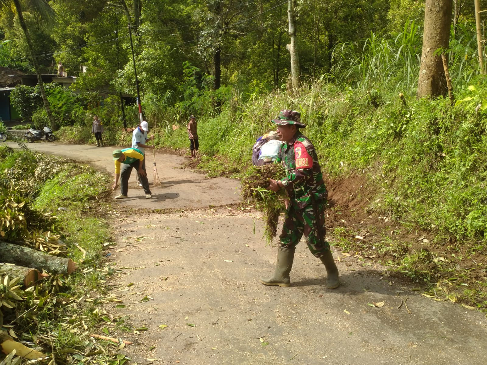 Babinsa dan Warga Desa Klodan Gelar Gotong Royong Bersihkan Ranting Pohon di Bahu Jalan