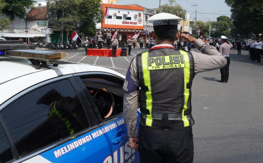 Petugas Satlantas Polres Jombang dan pengguna jalan hormat ke bendera merah putih dan berhenti sejenak menghormati jasa pahlawan di detik-detik Proklamasi Kemerdekaan di Bundaran Ringin Contong Jombang (Saha/SRTV)