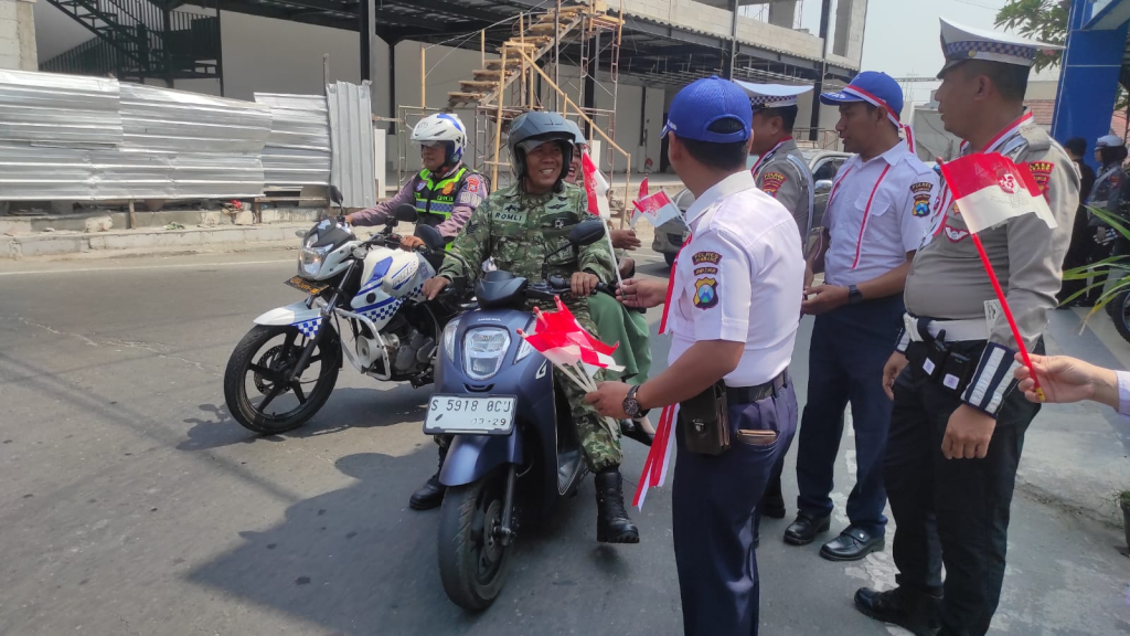 Petugas membagikan bendara merah putih di bundaran Ringin Contong Jombang (Saha/SRTV)
