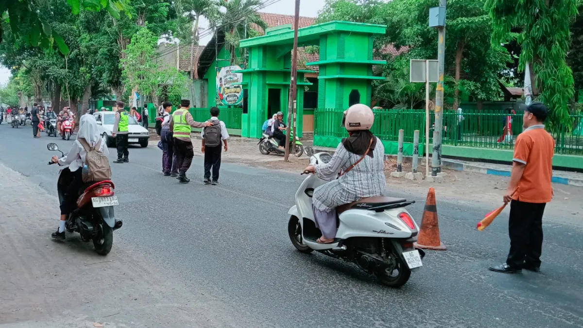 Kawal Jam Rawan Sekolah, Polsek Warujayeng Pastikan Pelajar SMPN 1 Tanjunganom Menyeberang dengan Aman