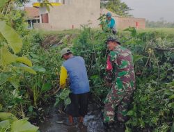 Babinsa Prambon Bersama Warga Gotong Royong Bersihkan Aliran Sungai di Desa Kurungrejo
