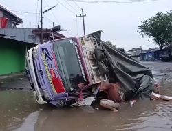 Rusak Parah, Jalan Arum Dalu Guyangan Jadi ‘Kolam’ Truk Muat Keramik Jadi Korban